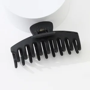 Détail d'une pince à cheveux noire mate avec dents antidérapantes et ressort métallique