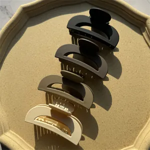 Set di quattro grandi mollette per capelli opache in toni terra su vassoio