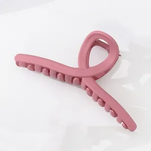 Makro-Detail einer großen mattrosa Haarklammer mit Schleifen-Design für Damen