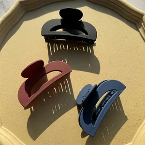 Set di 3 mollette per capelli opache nere, rosse e blu navy su un vassoio