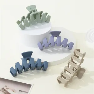 Detail view of large matte wave hair claws in soft Morandi colors on display