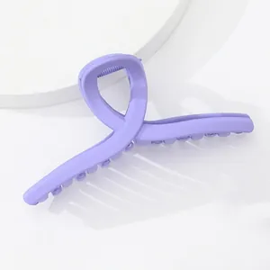 Vue détaillée d'une pince à cheveux violette mate avec un design croisé torsadé pour femme