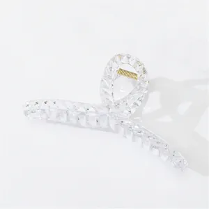 Detailed macro view of a clear acrylic hair claw with 3D diamond-cut surface textures