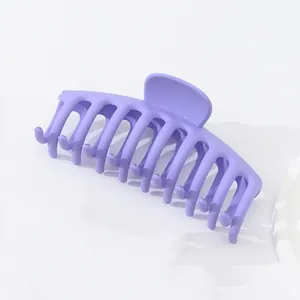 Détail d'une grande pince à cheveux violette mate montrant les dents et la texture
