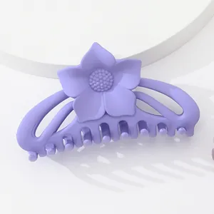 Détail macro d'une pince à cheveux fleur violette mate sur un support d'exposition