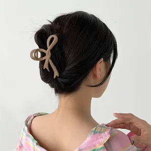 Coffee brown matte bow-shaped hair claw clip for women shown on model hair