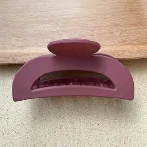 Dettaglio molletta per capelli opaca color malva con denti forti su vassoio legno