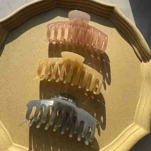 Close-up of three large matte jelly dragon bone hair claws in pastel Morandi colors