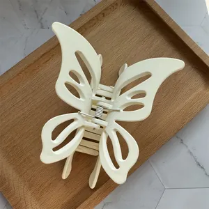 Detail of cream hollow butterfly hair claw clip with matte finish and metal spring
