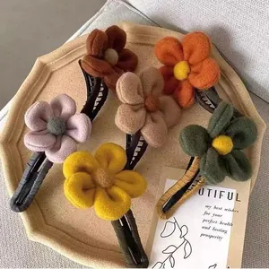 Winterliche Plüsch-Blumen-Haarspangen in sechs Farben auf einer eleganten Ablage