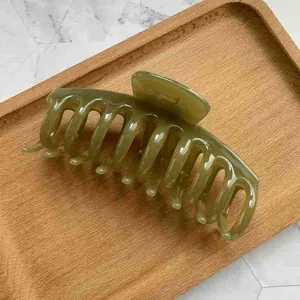 Detailed close-up of large olive green jelly hair claw clip with glossy finish