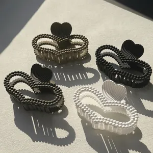 Set of four matte heart-shaped hair claw clips with beaded edges in assorted neutral colors