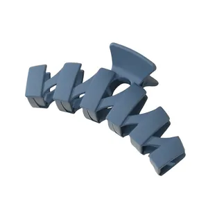 Detail of matte dark blue hair claw clip with geometric stepped design for women