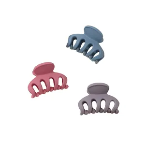 Detailed view of three matte hair claws in dusty blue, rose pink, and soft purple colors