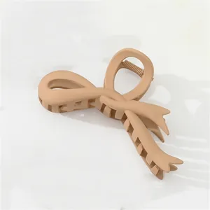 Close-up of matte khaki hair claw clip with a minimalist bow design and sturdy teeth