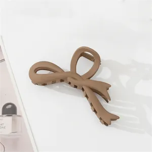 Detail of dark brown matte hair claw clip featuring a creative ribbon bow design