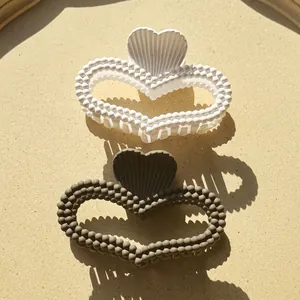 Matte heart-shaped hair claw clips with beaded texture in white and dark grey colors