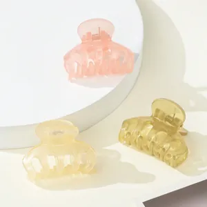Detailed view of three mini matte hair claws in pink, yellow and olive green colors