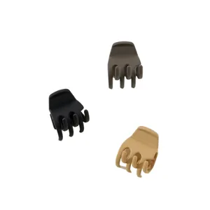 Detailed view of three matte small hair claws in black, brown, and beige tones