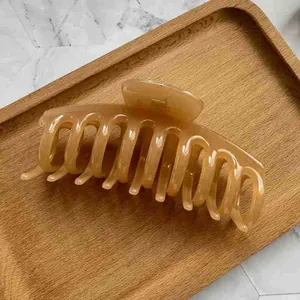 Detail of a large amber resin hair claw clip with a glossy finish and strong spring