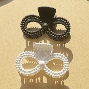 Detail view of large matte double ring hair claw clips with beaded texture in black and white