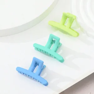Close-up of matte square claw clips in bright green, mint green, and sky blue colors