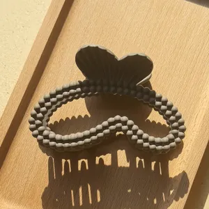 Dettaglio del fermaglio per capelli grigio opaco con texture a doppia fila di perle