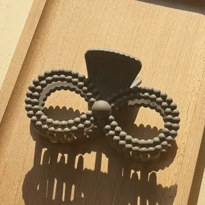 Macro view of matte dark grey shark hair claw with unique bead texture and infinity shape