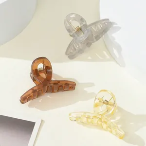 Detailed view of matte finish small shark hair clips in amber brown and grey colors