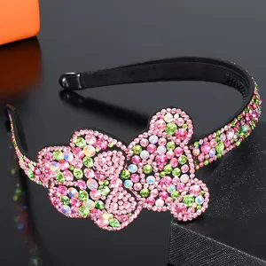 Detail of colorful crystal bear patterns and pink rhinestones on a black headband