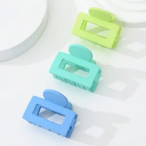 Close-up of 3-pack matte mini square hair claws in neon green, mint and sky blue colors
