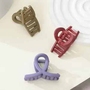 Detail view of matte hair clips in olive green, vintage red and lavender colors
