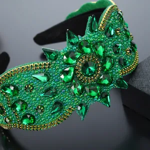 Dettaglio del cerchietto in velluto verde smeraldo con cristalli e bordo a catena dorata