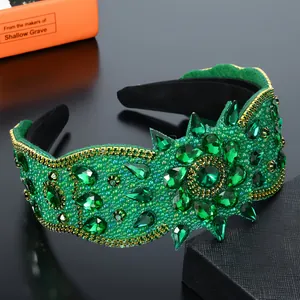 Dettaglio del cerchietto verde smeraldo con strass, perle dorate e fiori di cristallo