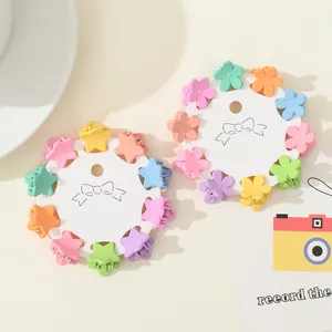 Mini floral and star hair claws in macabre colors displayed on white cards