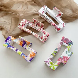 Set mit vier rechteckigen Haarklammern mit verschiedenen bunten Blumenmustern und Motiven