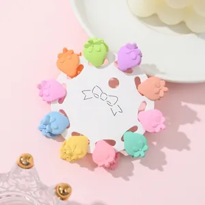 Close-up of strawberry mini hair clips in macaron colors on a white display card