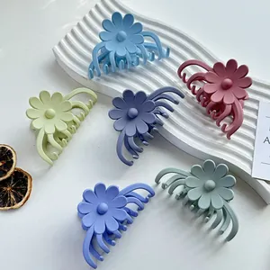 Set mit sechs matten Blumen-Haarklammern in Pastellfarben auf weißem Display