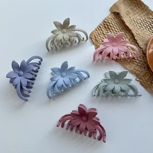 Set mit sechs bunten, matten Blumen-Haarklammern in Pastelltönen auf weißem Grund
