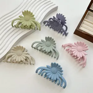 Daisy petal hair claws in assorted Morandi colors on a minimalist wave tray