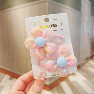 Detail of two pink mesh flower hair clips with sequins on a branded paper card