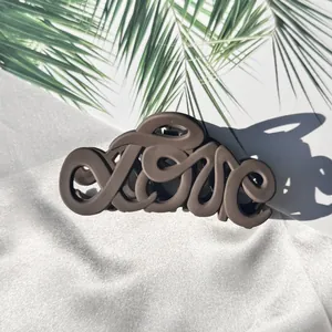 Nahaufnahme einer matten braunen Haarklammer mit einem kreativen LOVE-Schriftdesign