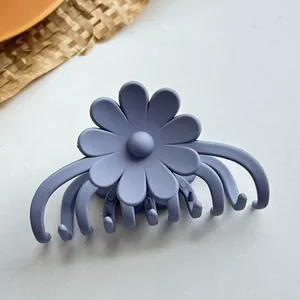 Nahaufnahme der matt lila Gänseblümchen-Haarklammer mit Multi-Zahn-Griff-Design