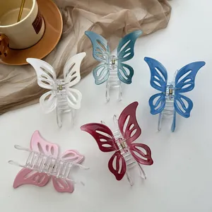Five hollow butterfly hair claws in white, blue, pink, and burgundy on a white table