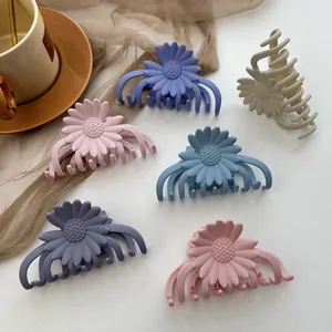 Set of six matte daisy hair claws in diverse pastel colors with a sleek flower design