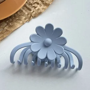 Makroansicht einer hellblauen matten Blumen-Haarklammer mit feinem Gänseblümchen-Design