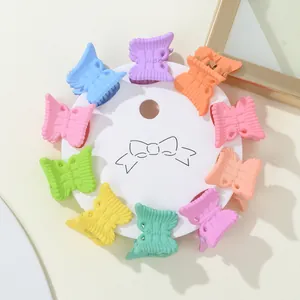 Detailed view of ten colorful mini butterfly hair clips on a white round card