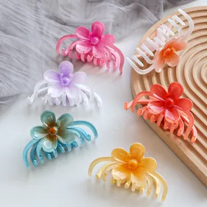 Colorful matte flower hair claws in six vibrant candy colors on a wooden display tray