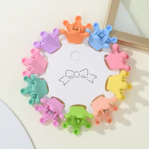 Close-up of 10 mini crown-shaped hair clips in matte pastel colors on a paper card