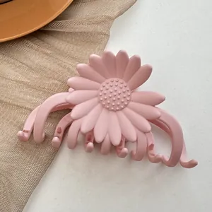 Detailed view of large pink daisy hair claw clip with matte finish on white background